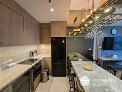 Modern kitchen with sleek design, featuring marble countertops and integrated appliances.