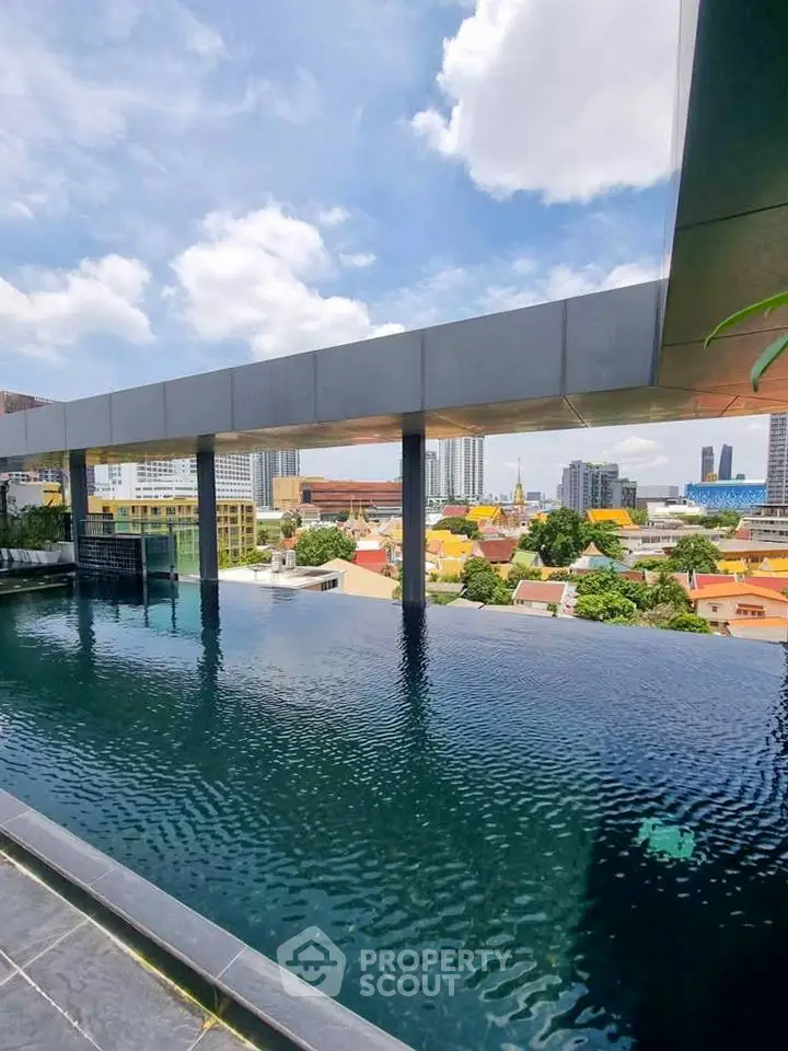 Luxurious rooftop infinity pool with stunning cityscape views under a clear blue sky.