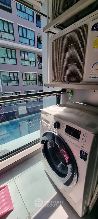 Modern condo balcony with washing machine and pool view, perfect for urban living.