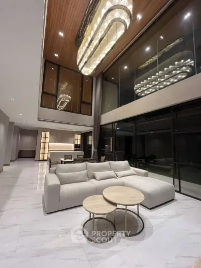 Luxurious modern living room with high ceilings and elegant chandelier