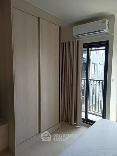 Modern bedroom with built-in wardrobe and balcony access in urban apartment