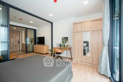 Modern bedroom with stylish furniture and large windows in a contemporary apartment.