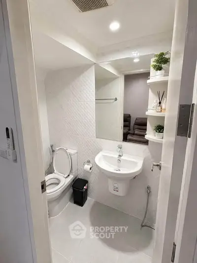Modern bathroom with sleek fixtures and stylish shelving in a compact space.