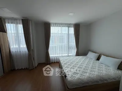 Spacious bedroom with large windows and modern decor, perfect for natural light lovers.