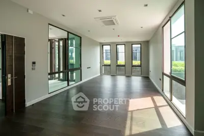 Spacious modern living room with large windows and hardwood floors