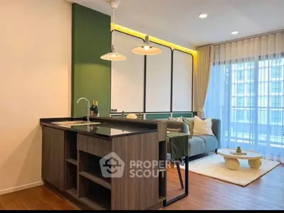 Modern living room with stylish kitchen island and cozy seating area, featuring large windows and elegant lighting.