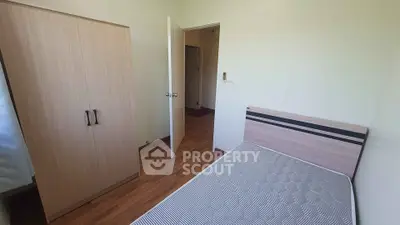 Cozy bedroom with wooden wardrobe and comfortable bed in modern apartment.