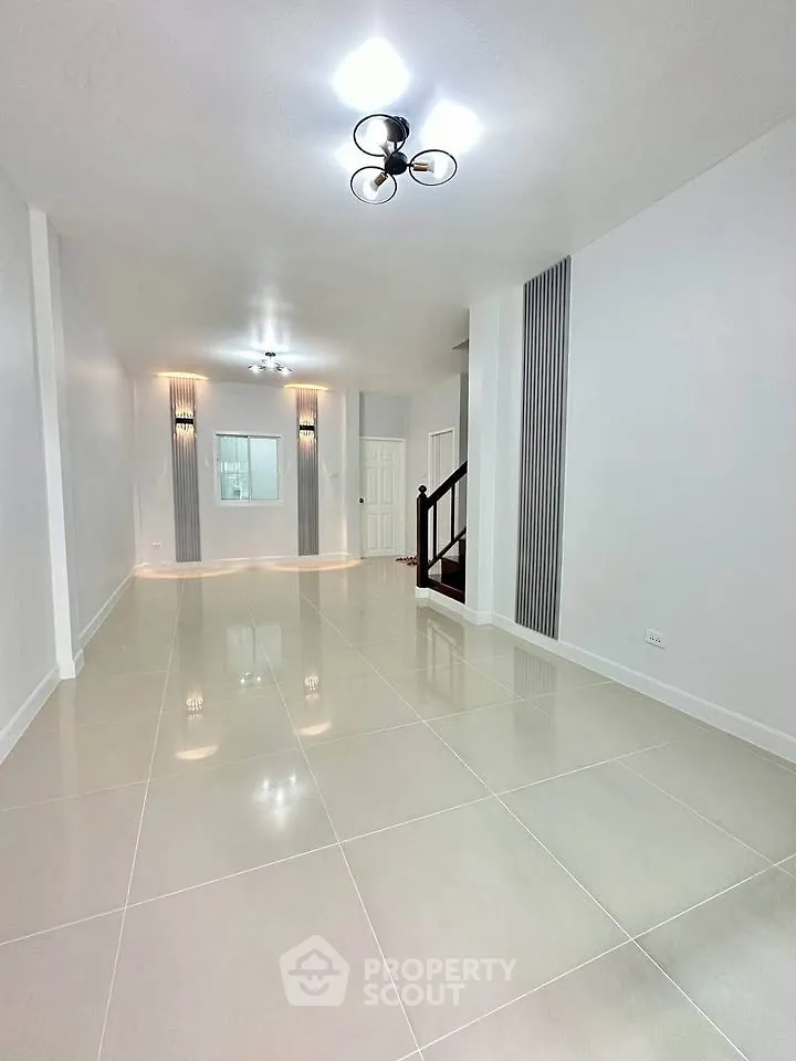 Spacious modern living room with elegant lighting and glossy tiled flooring.