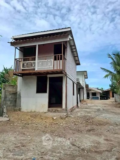 Charming two-story rustic house with balcony in a serene rural setting, perfect for a peaceful lifestyle.