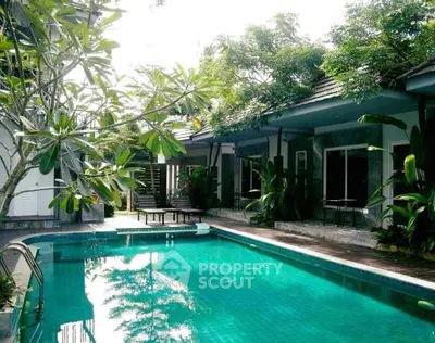 Luxurious villa with a stunning private pool surrounded by lush greenery, perfect for relaxation and leisure.