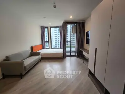Modern studio apartment with large windows and minimalist furniture