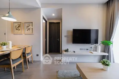 Modern living room with dining area, wall-mounted TV, and stylish decor