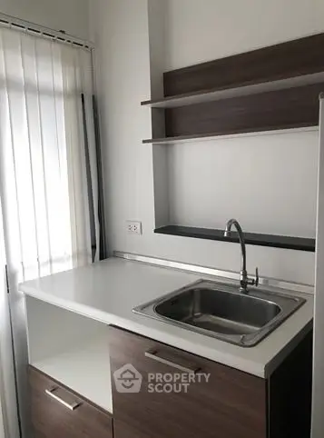 Modern kitchen with sleek cabinetry and stainless steel sink, perfect for urban living.