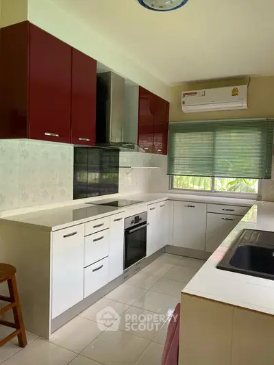 Modern kitchen with sleek cabinetry and built-in oven, featuring a bright and airy atmosphere.