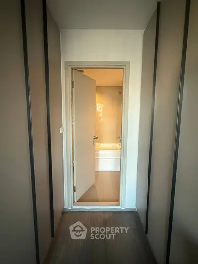 Cozy hallway leading to a modern bathroom with bathtub