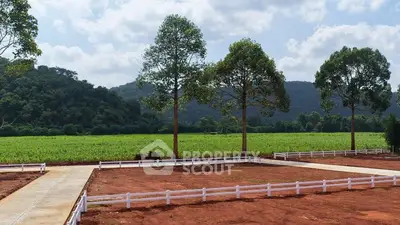 Scenic plot of land with lush greenery and mountain views, ideal for development.