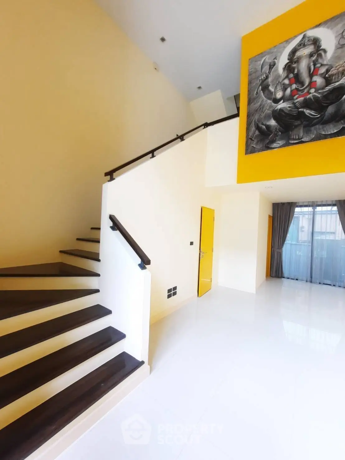 Modern duplex interior with elegant staircase and vibrant wall art