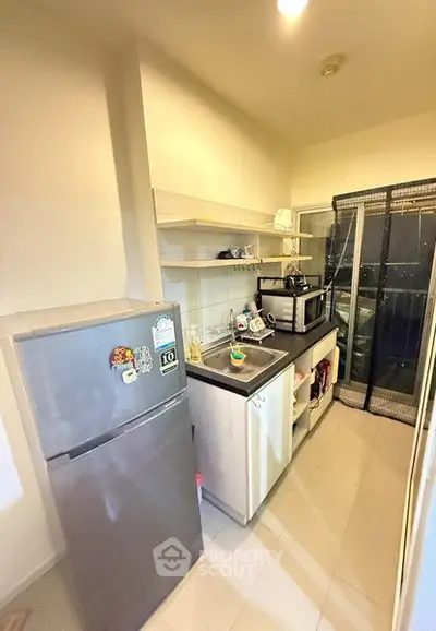 Compact kitchen with modern appliances and balcony access