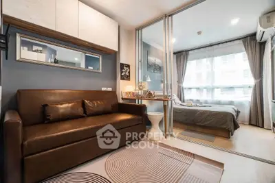 Modern studio apartment with stylish living area and cozy bedroom separated by glass partition.