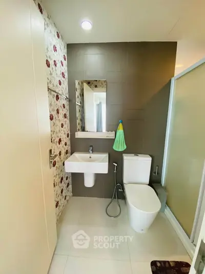 Modern bathroom with floral accent wall and sleek fixtures in a contemporary apartment.