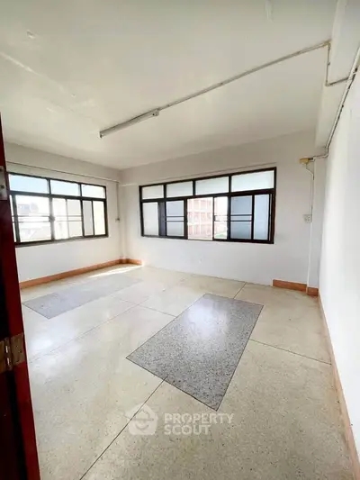 Spacious unfurnished room with large windows and natural light, ideal for customization.