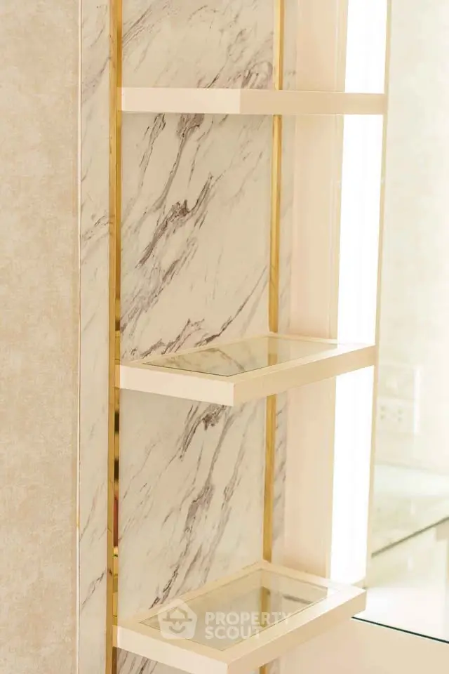 Elegant marble shelves with gold accents in a luxurious bathroom setting.