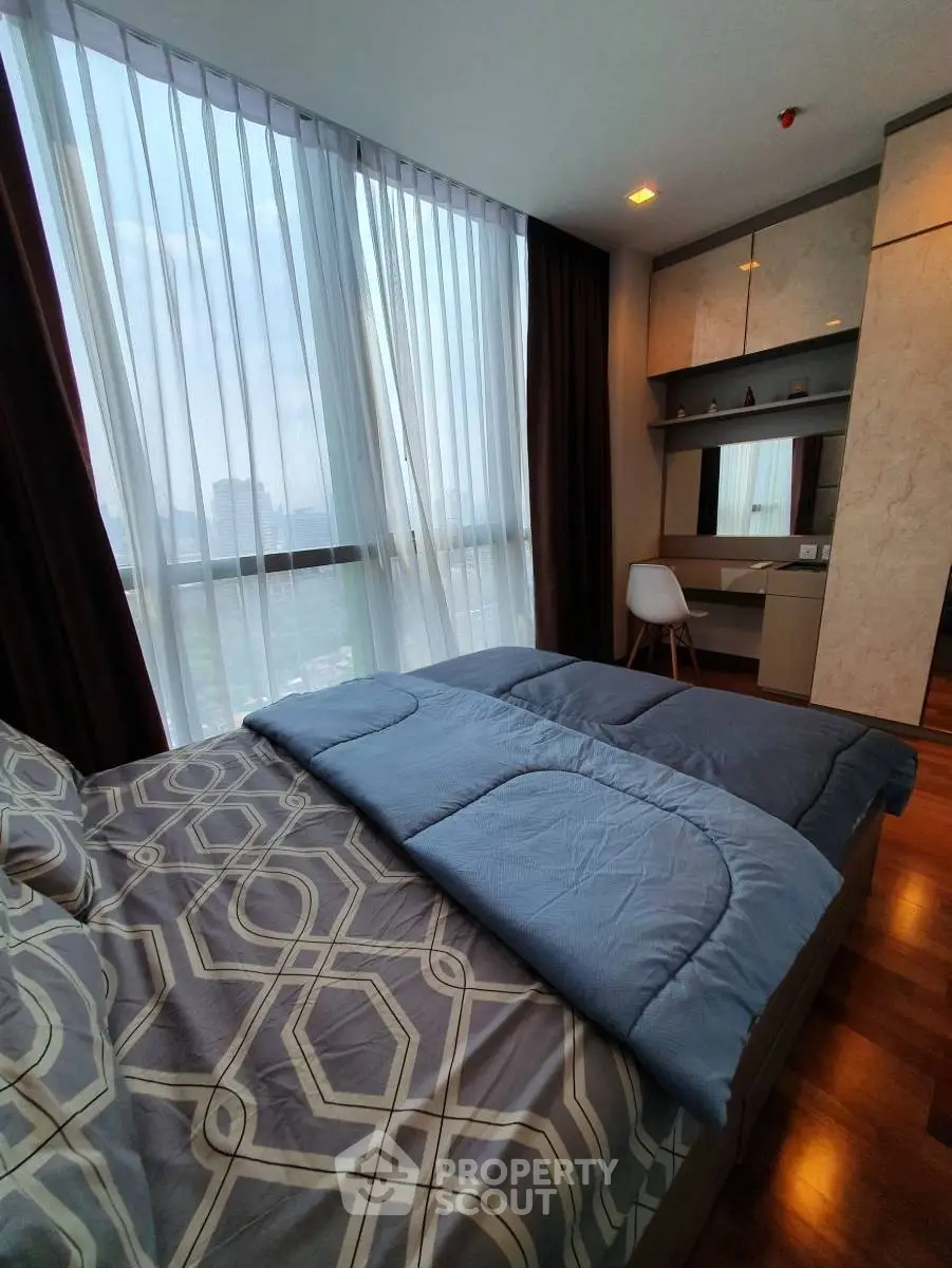 Modern bedroom with large windows and stylish decor in a high-rise apartment.