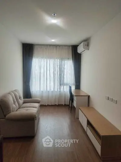 Cozy living room with modern furniture and large window for natural light.