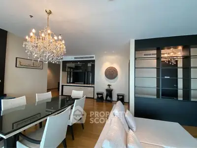 Luxurious dining area with elegant chandelier and modern decor in a spacious living room.