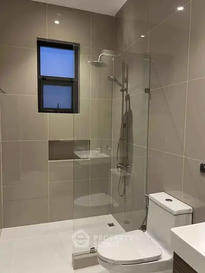 Modern bathroom with sleek glass shower and contemporary fixtures.