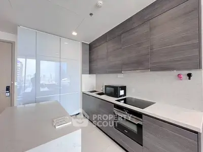 Modern kitchen with sleek cabinetry and built-in appliances in a high-rise apartment.