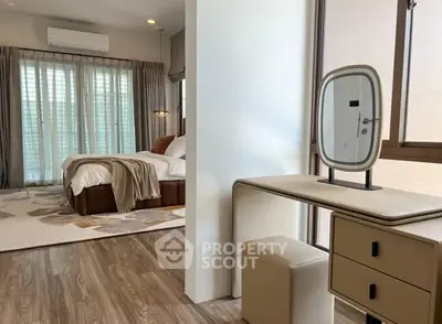 Luxurious bedroom with elegant decor and natural light, featuring a stylish vanity area.