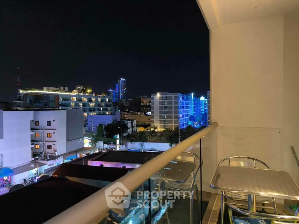 Stunning city view from modern balcony at night with vibrant lights