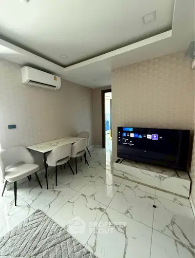 Modern living room with sleek marble flooring and wall-mounted TV, featuring a cozy dining area and air conditioning.
