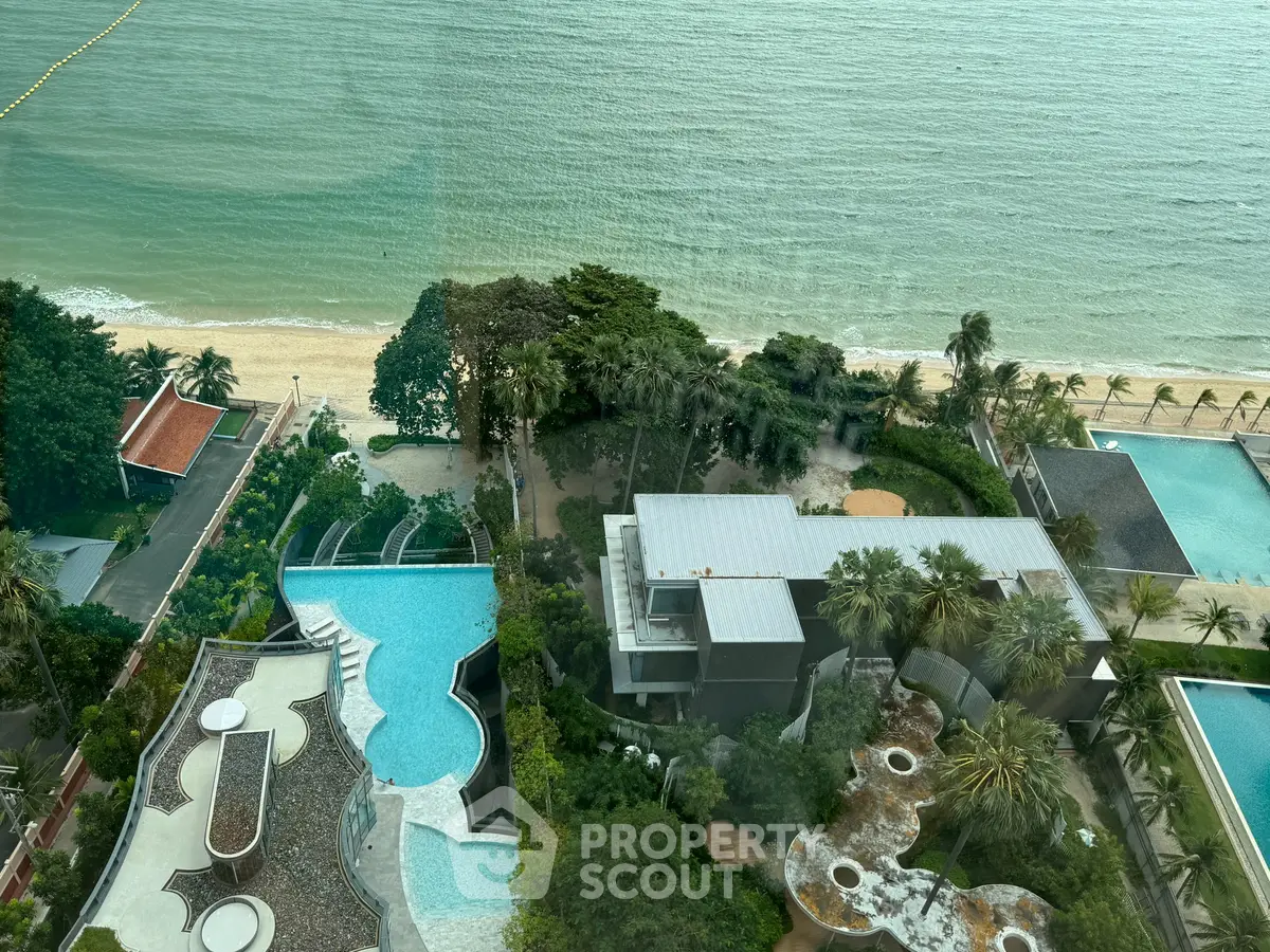 Stunning beachfront view from high-rise building with lush greenery and modern architecture.