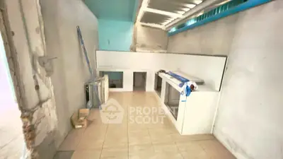 Spacious unfinished kitchen area with tiled floor and basic cabinetry