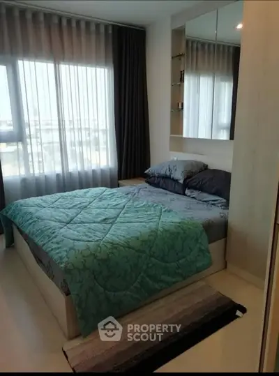 Cozy bedroom with large window and modern decor in a stylish apartment.