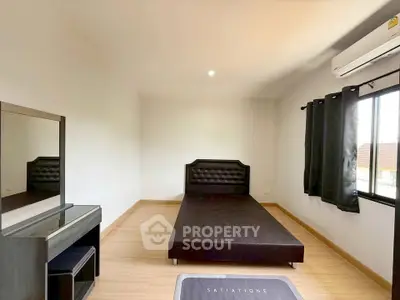 Spacious bedroom with modern furnishings and natural light