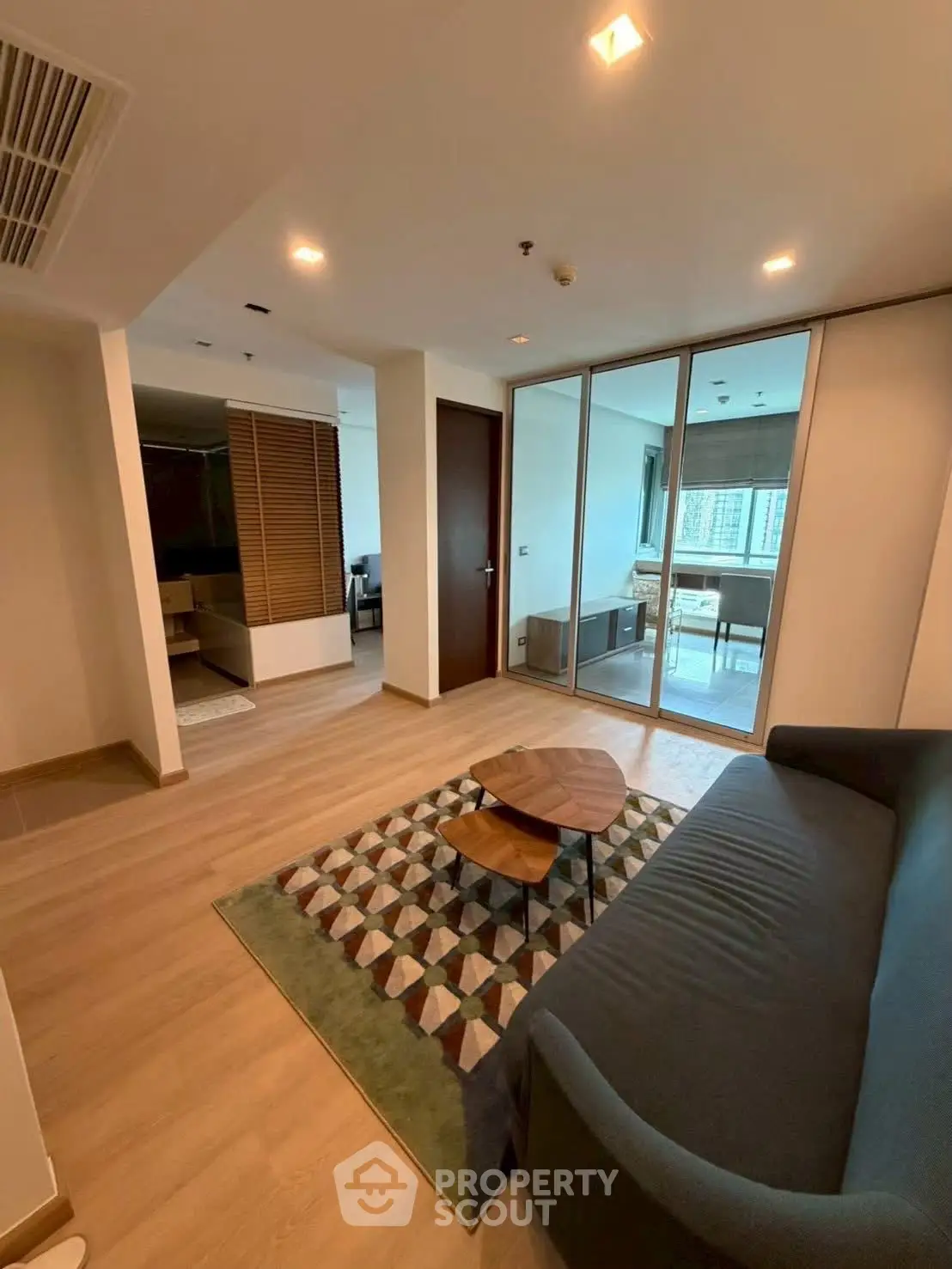 Modern living room with stylish decor and balcony view in upscale apartment.