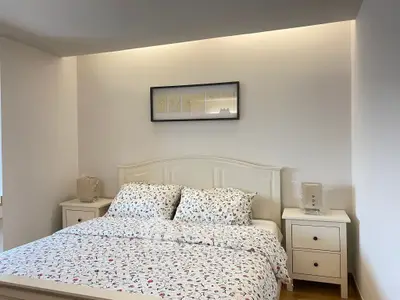 Cozy bedroom with elegant decor and floral bedding in a modern real estate listing.