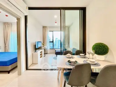 Modern open-plan living and dining area with city view, featuring stylish decor and natural light.