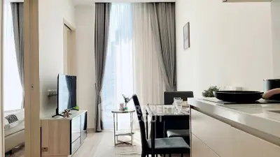 Modern living room with dining area and natural light in a stylish apartment.
