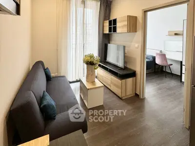 Modern living room with sleek furniture and natural light, adjacent to a cozy bedroom.