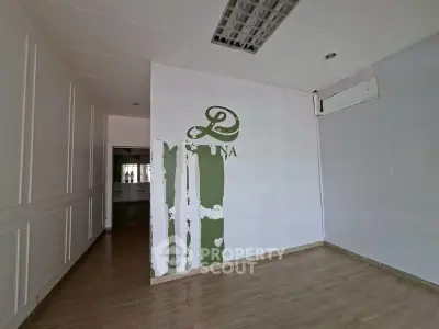 Spacious interior with wooden flooring and unique wall design, ideal for creative renovation.