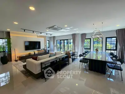 Luxurious open-plan living room with modern decor and large windows.