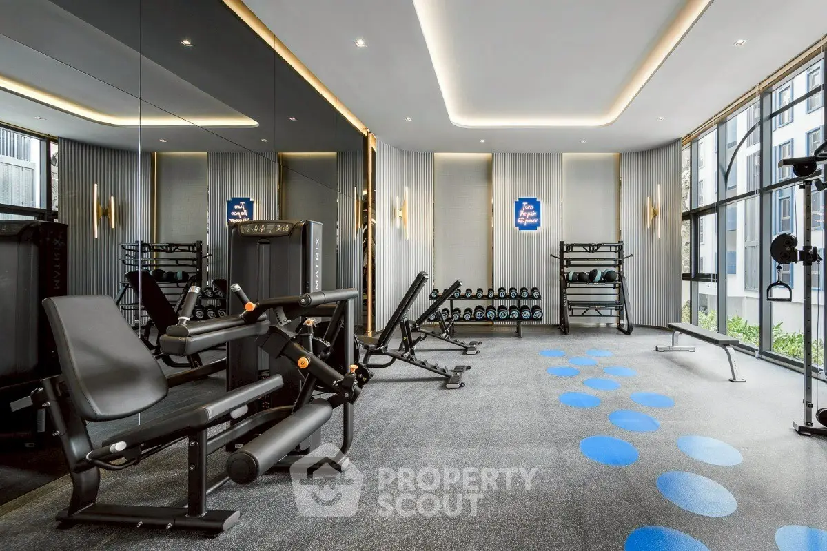 Modern gym with state-of-the-art equipment and mirrored walls in a luxury residential building.