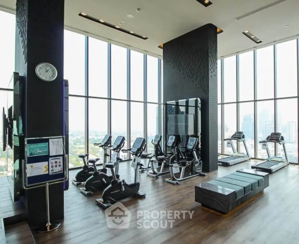 Luxurious high-rise gym with panoramic city views and modern fitness equipment.