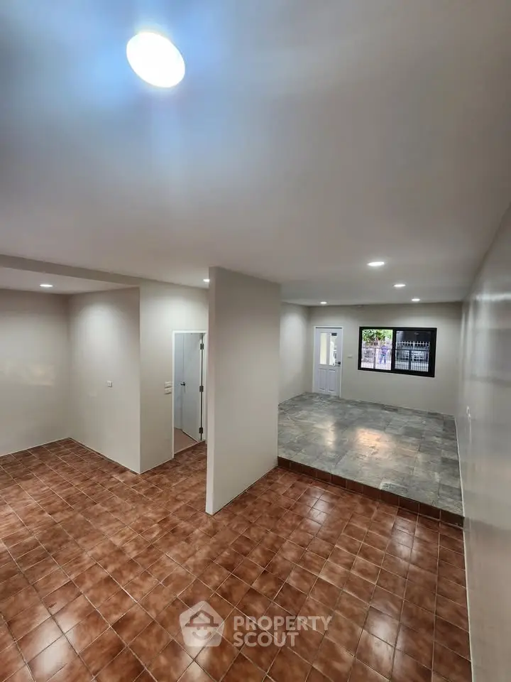 Spacious interior with tiled flooring and modern lighting, perfect for versatile living arrangements.