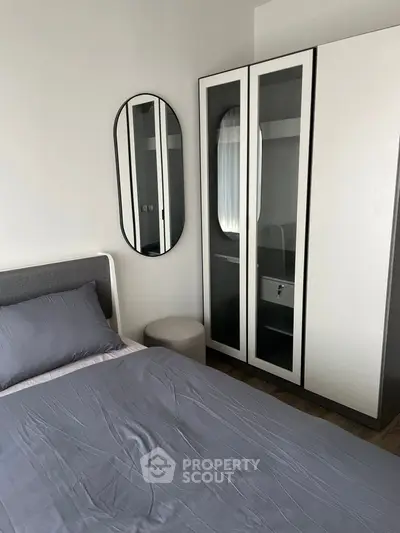 Modern bedroom with sleek wardrobe and stylish mirror, perfect for urban living.