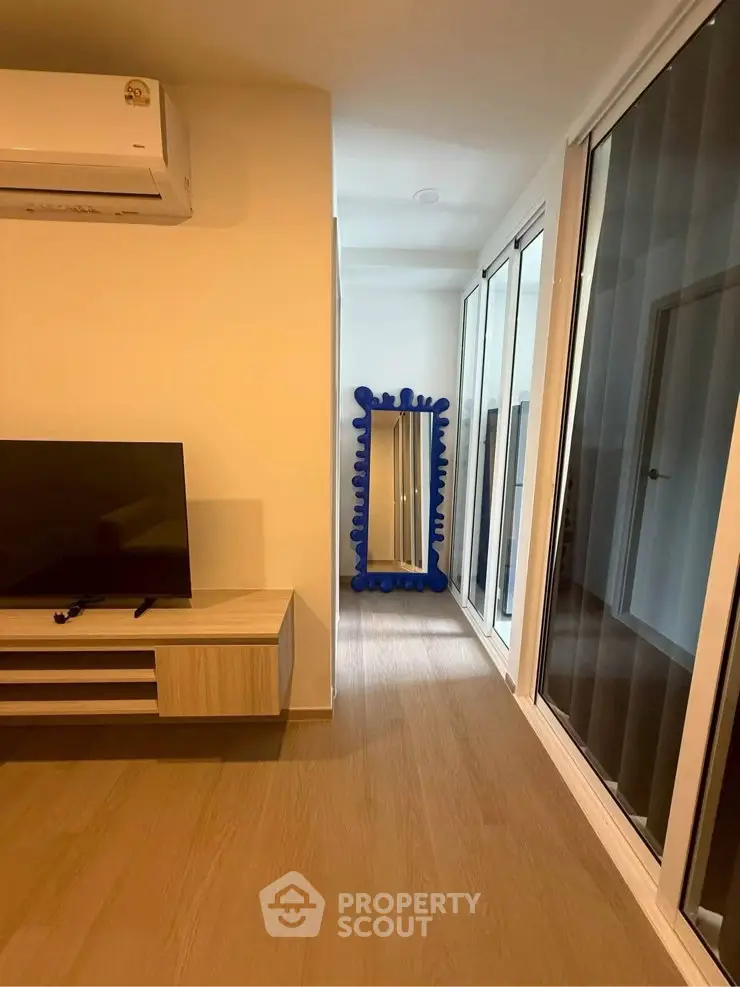 Modern living room with stylish decor and large mirror, featuring sleek wooden flooring and contemporary furniture.